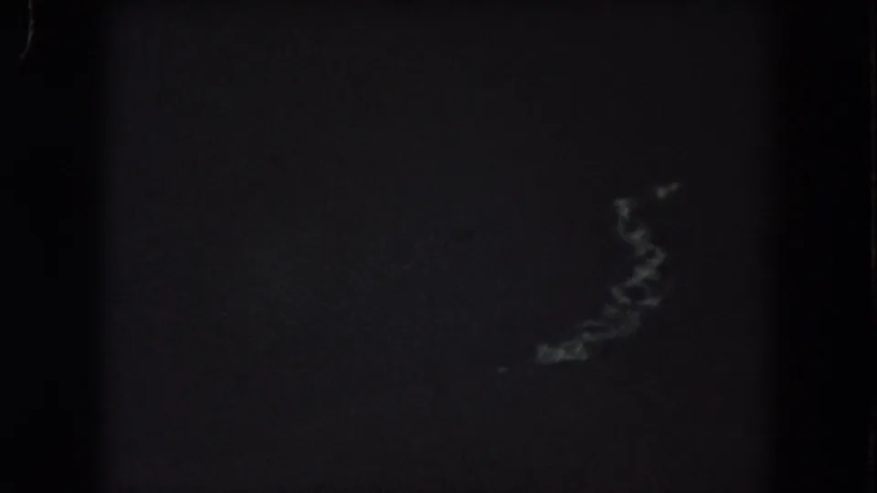 1962 Summit County 8mm frame with an almost black nighttime view and faint, soft light traces near the upper center.