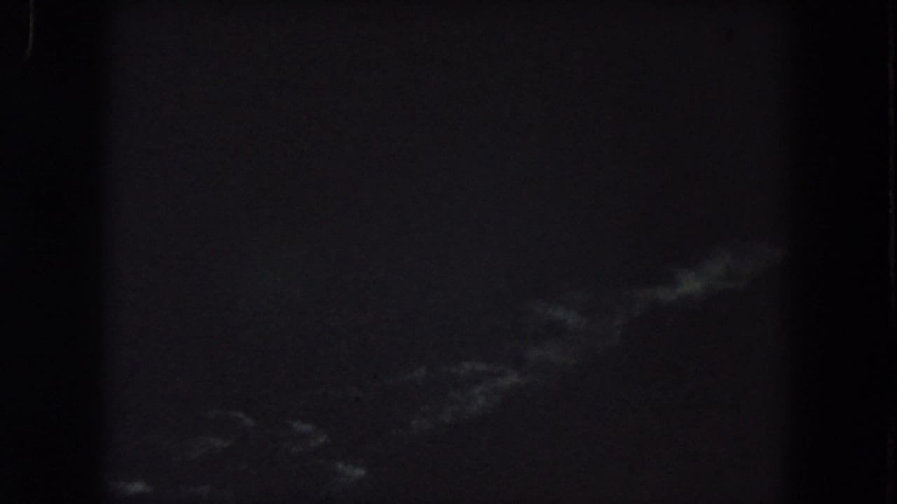 Summit County 1962 8mm frame with faint pale storm-like streaks at the lower right and heavy nighttime underexposure.