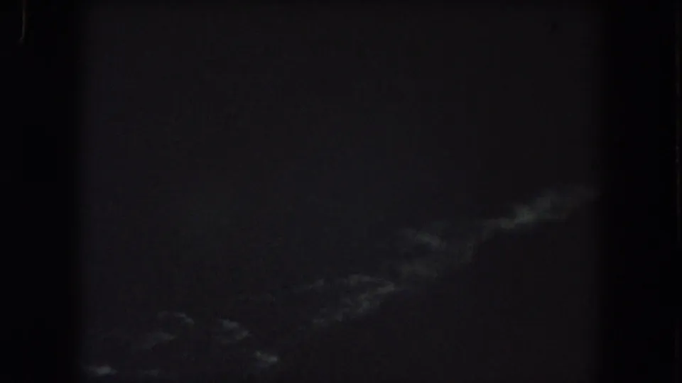 Summit County 1962 8mm frame with faint pale storm-like streaks at the lower right and heavy nighttime underexposure.