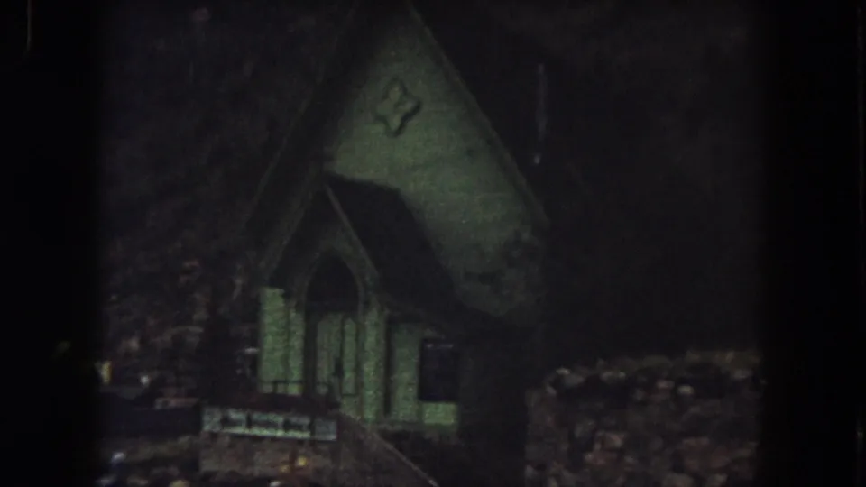 1962 Summit County, Colorado frame with the green church entrance held in a dark, grainy nighttime exposure.