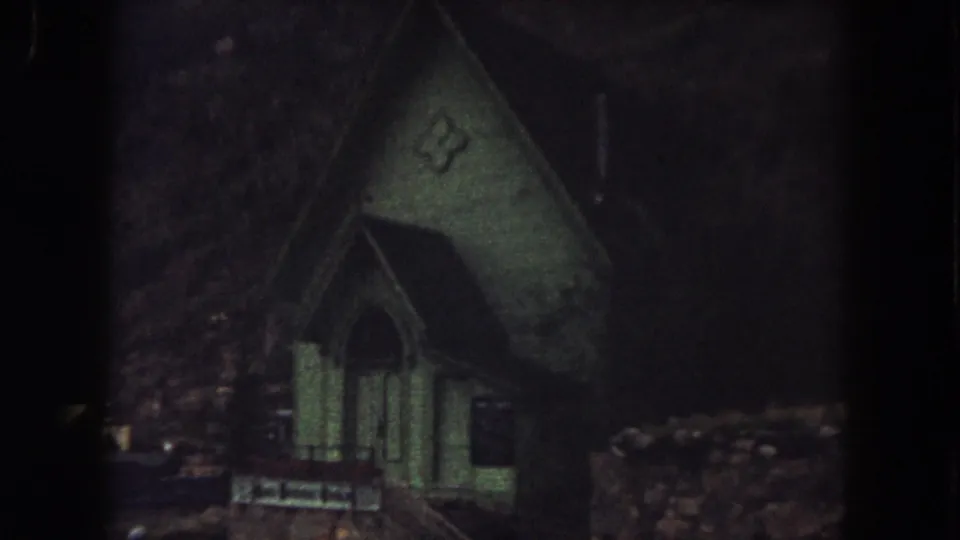 1962 Summit County, Colorado frame showing the small green church exterior in low light near the end of the clip.