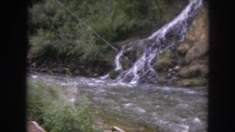 1962 Winter Park, Colorado 8mm view of fast water and a small cascade, partly softened by brush and film grain.