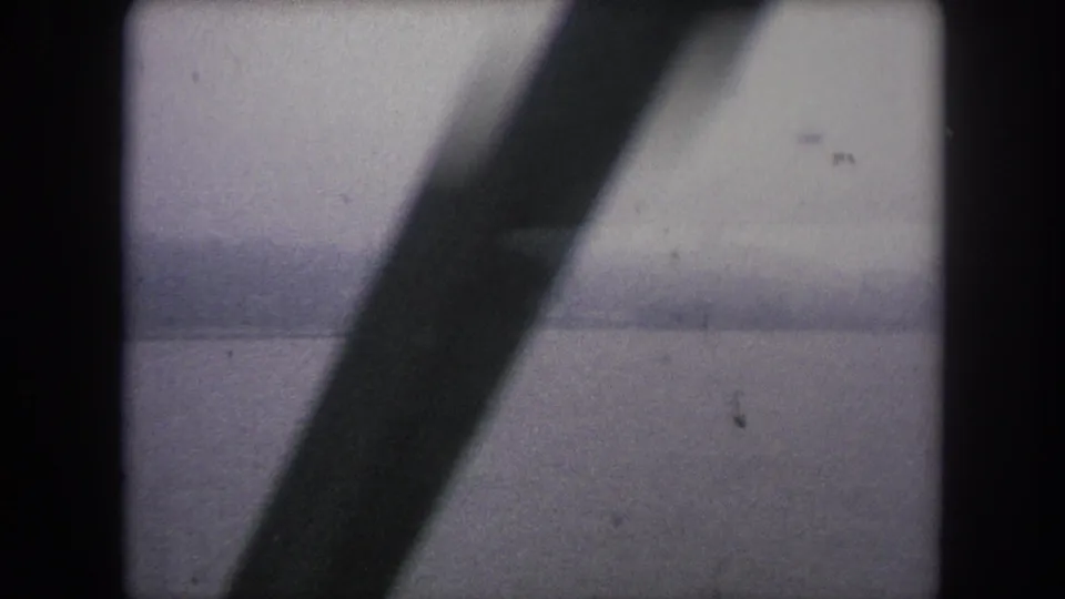 Winter Park, Colorado 1962 travel frame with a dark diagonal rail bridge beam obscuring part of the misty river view.