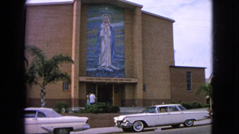 Barrington, Illinois 1963 church exterior with the Virgin Mary mosaic centered above the entrance and white mid-century cars parked in the foreground.