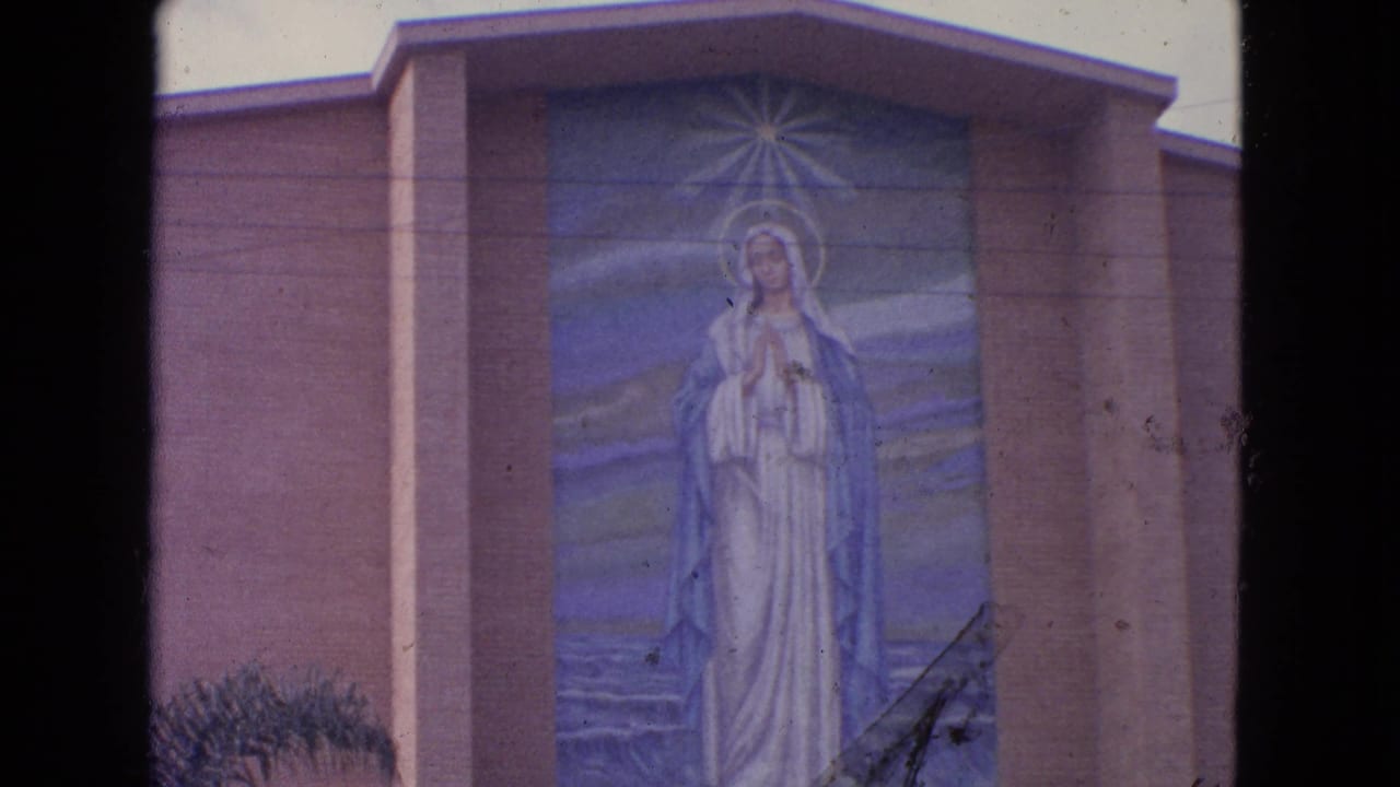 1963 Barrington, Illinois frame of a Marian wall mural on a church exterior, partly bordered by the 8mm contact sheet edge.