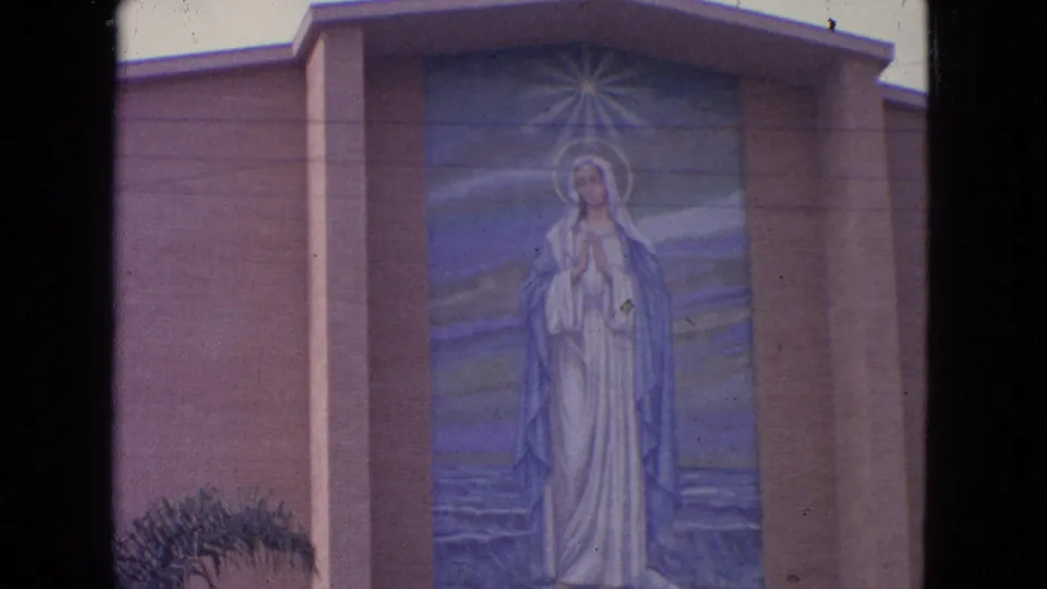 1963 Barrington, Illinois 8mm still showing a centered Virgin Mary mural on a church exterior facade.