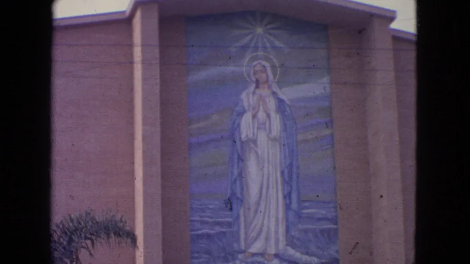 1963 Barrington, Illinois 8mm view of the Virgin Mary mural, with the figure centered on a blue-toned exterior panel.