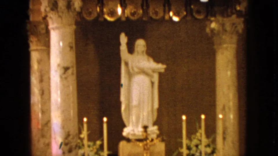 Closer 1963 church view of a white saint statue, altar candles, flowers, and marble columns in Barrington, Illinois.