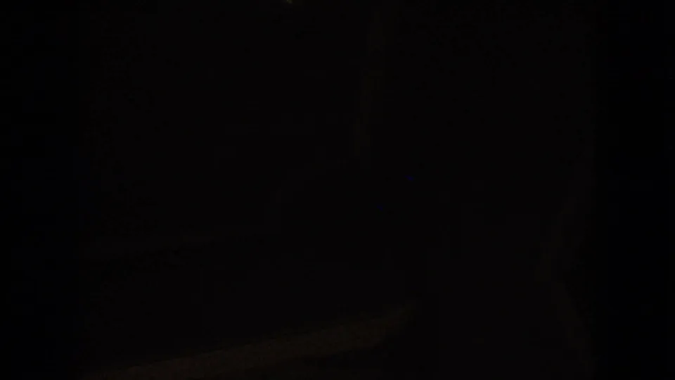Dark ending frame from the 1963 8mm clip, with only faint car-interior detail visible.