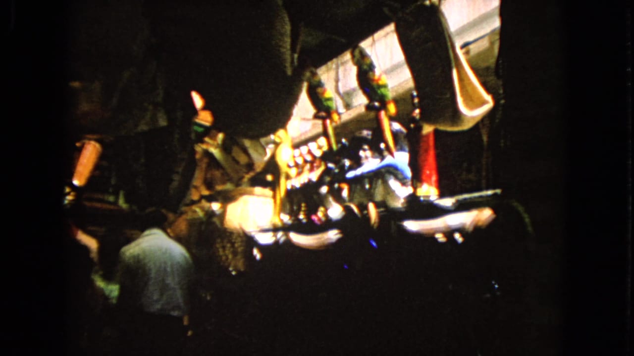 Adult seen from behind inside a dark room with bright gaming-machine lights ahead.