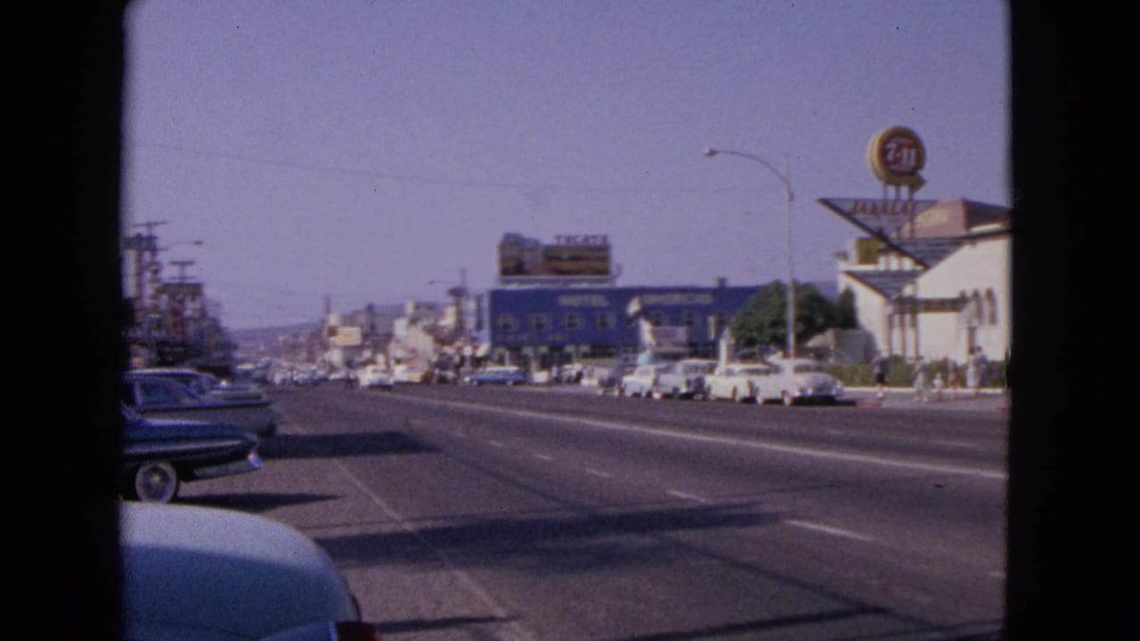 Barrington street scene from 1963 showing traffic lanes, early-1960s cars, motel signage, and small figures on the sidewalk.