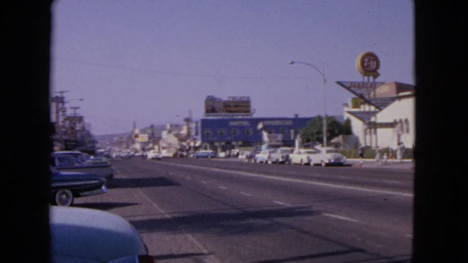 Barrington street scene from 1963 showing traffic lanes, early-1960s cars, motel signage, and small figures on the sidewalk.