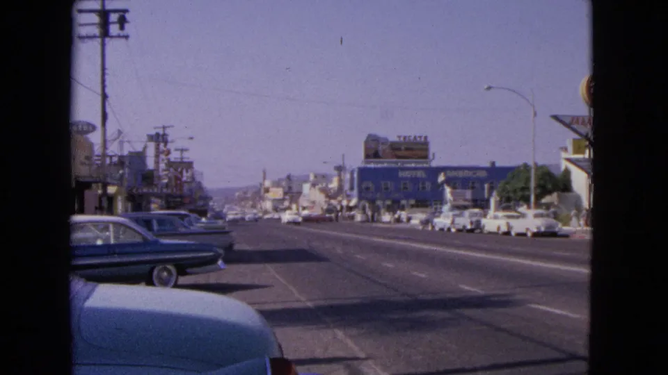 Barrington, Illinois street scene in 1963 with a blue sedan, parked cars, commercial buildings, and motel and roadside signage.