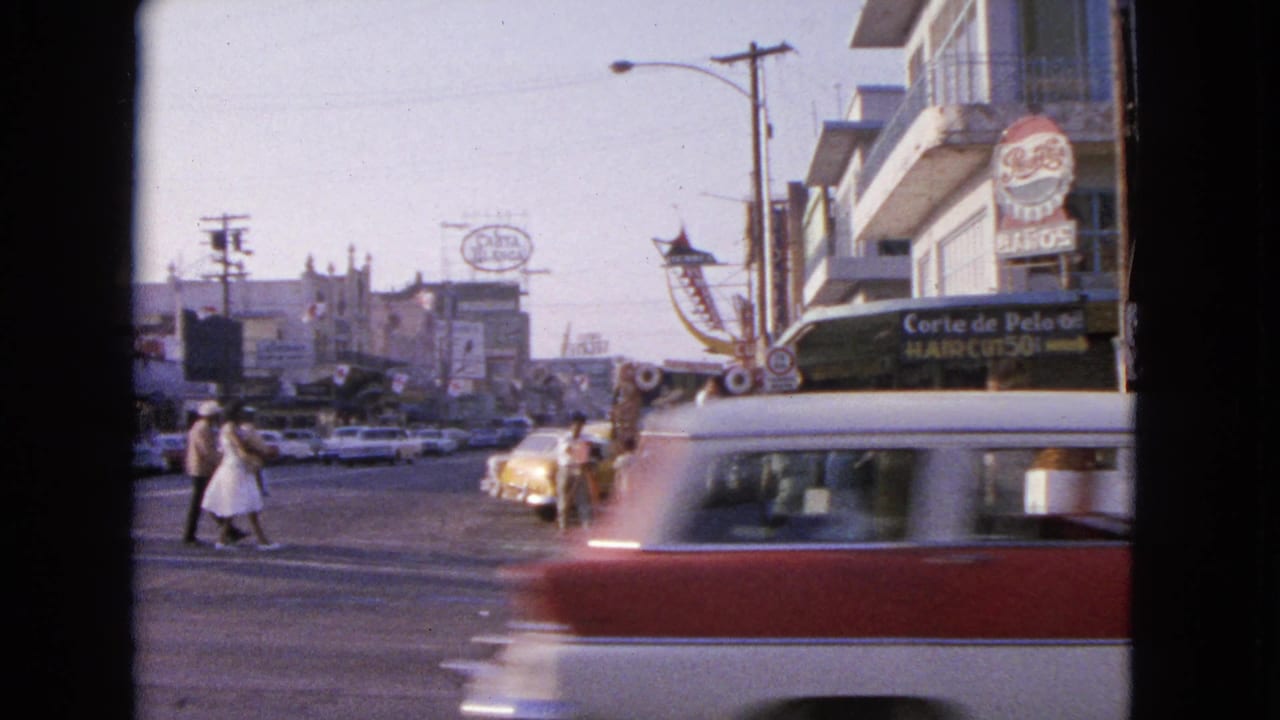 1963 Barrington, Illinois street view with pedestrians crossing, classic cars, storefront signs, and mid-century commercial buildings.