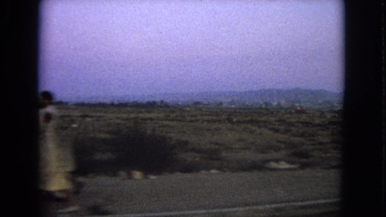 1963 Barrington, Illinois roadside view with a briefly visible woman in a light, possibly yellow, dress.