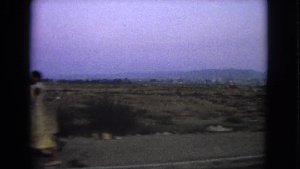 1963 Barrington, Illinois roadside view with a briefly visible woman in a light, possibly yellow, dress.