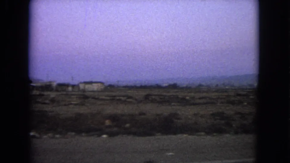 1963 Barrington, Illinois frame showing low buildings beyond an open roadside landscape.