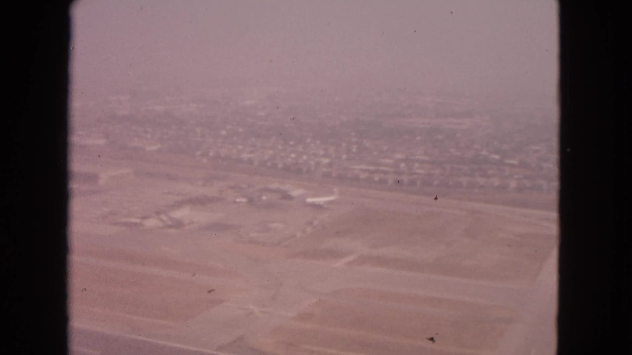 Barrington, Illinois airport area viewed from above in 1963, with runway strips, low structures, and distant residential blocks.