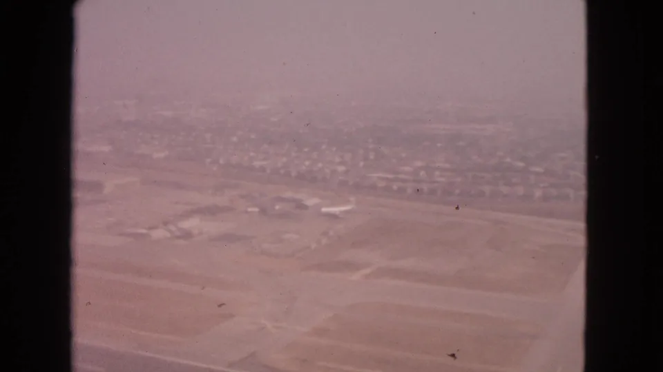 Barrington, Illinois airport area viewed from above in 1963, with runway strips, low structures, and distant residential blocks.