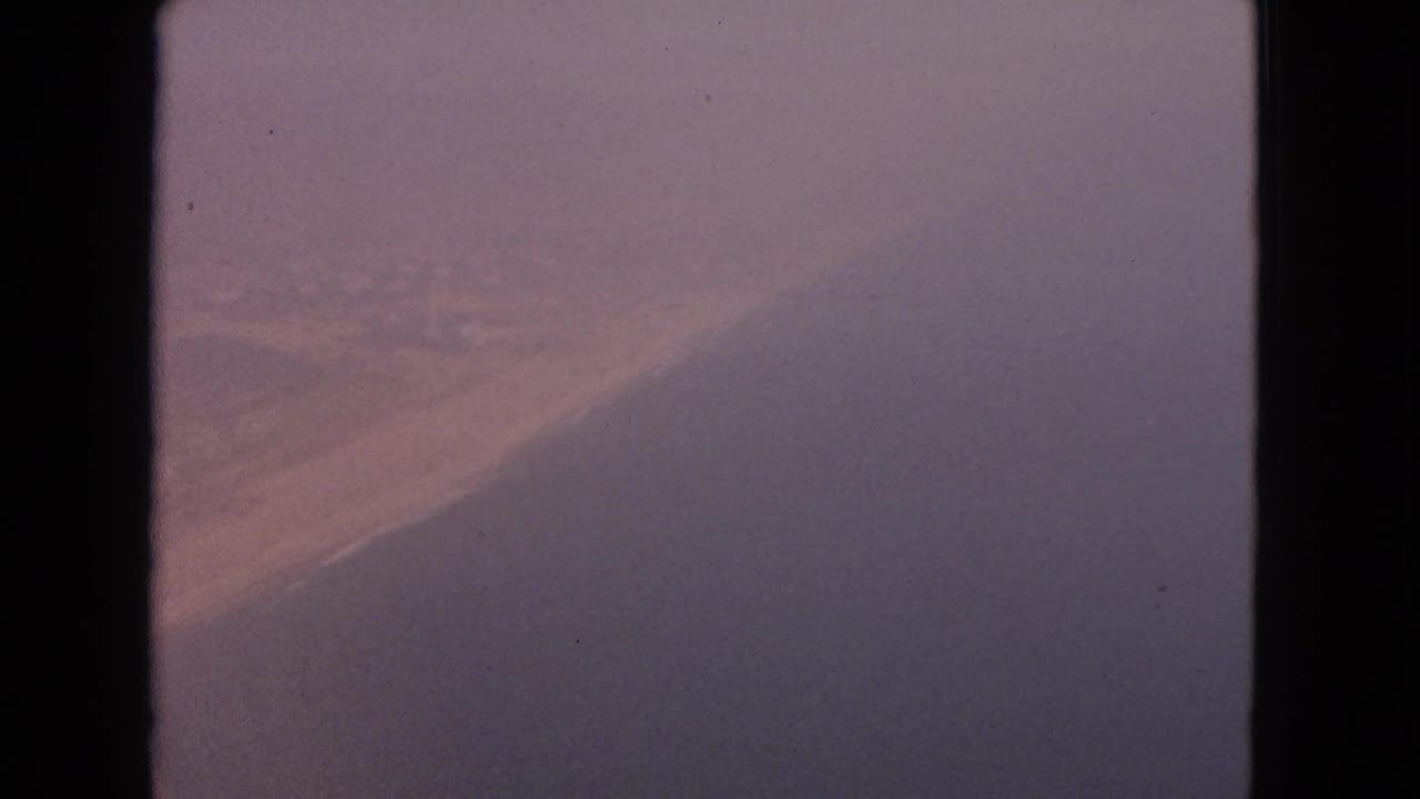1963 8mm aircraft-window view labeled Barrington, Illinois, with fog-muted color and a broad shadowed wing or window form.