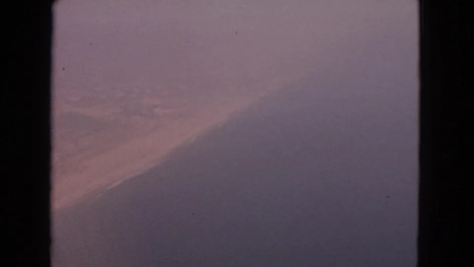 1963 8mm aircraft-window view labeled Barrington, Illinois, with fog-muted color and a broad shadowed wing or window form.