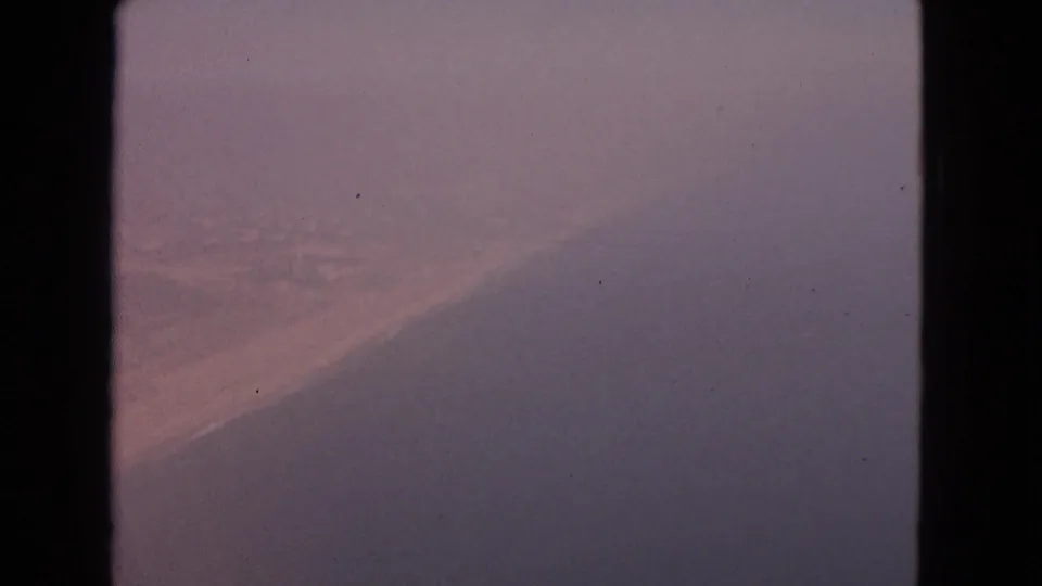 1963 8mm travel footage labeled Barrington, Illinois, showing a fog-obscured aerial view beside a dark aircraft or window border.