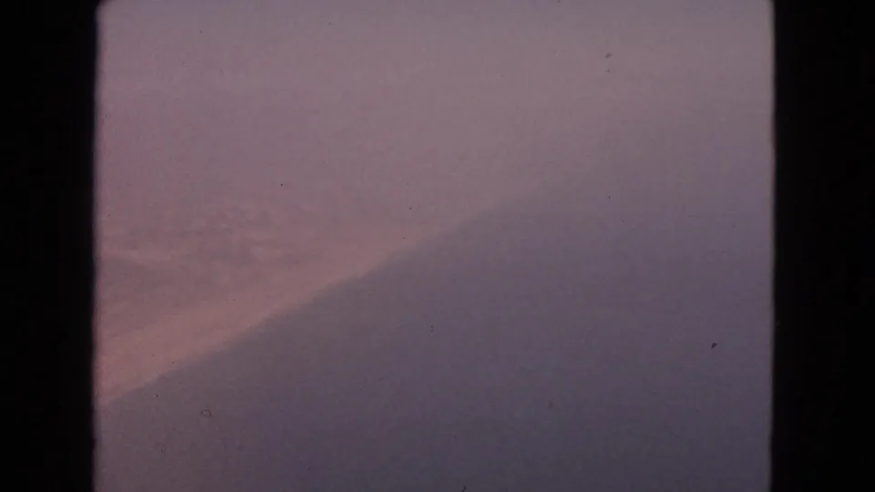 1963 8mm airplane-window view labeled Barrington, Illinois, with fog, muted tones, and little identifiable landscape detail.