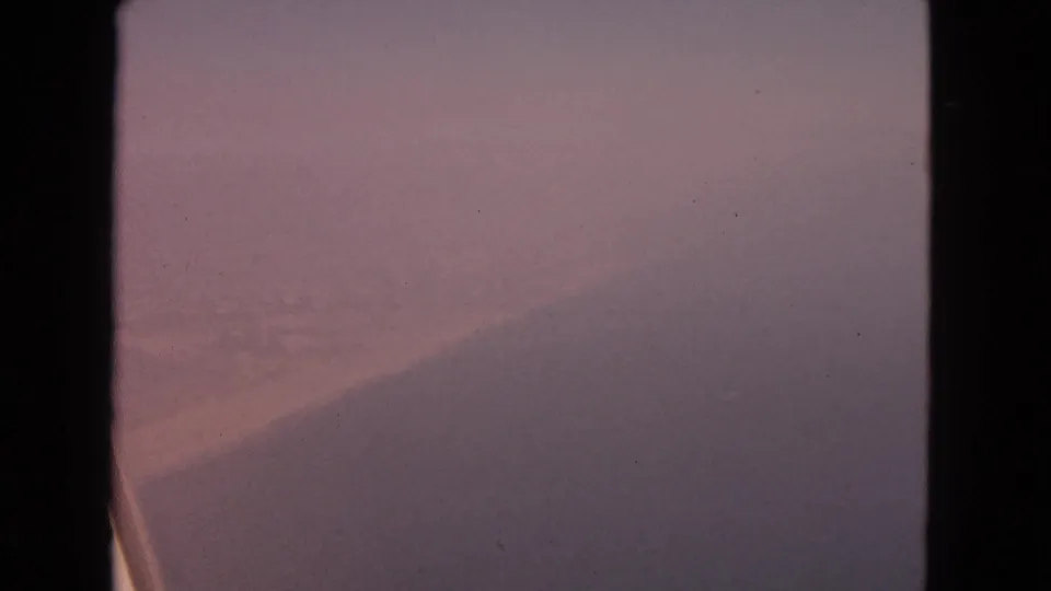 A soft 1963 passenger-window view over a snow-covered Illinois landscape, with the airplane wing low in frame.