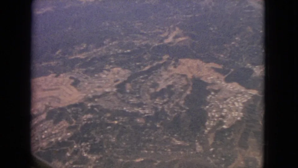 Final 1963 airplane-window view over Barrington-area terrain, with roads, fields, wooded patches, and visible development below.