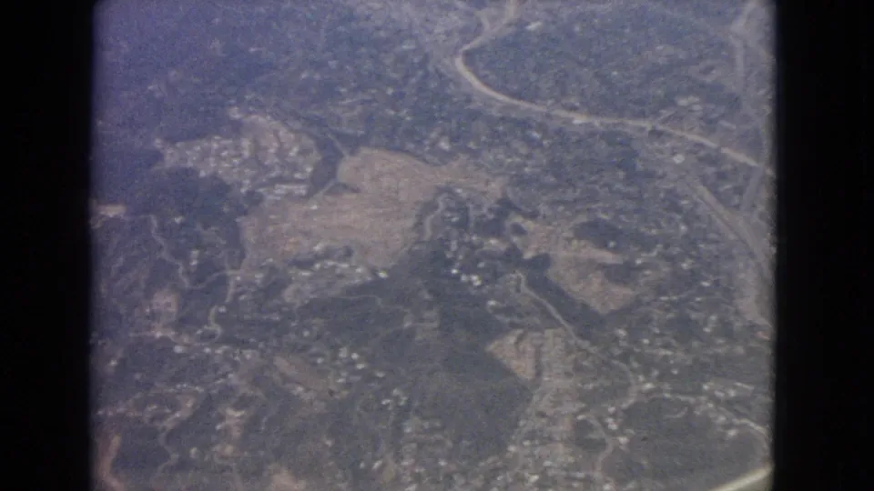 Aerial 8mm frame over Barrington, Illinois, showing curving roads, wooded ground, fields, and small building clusters.