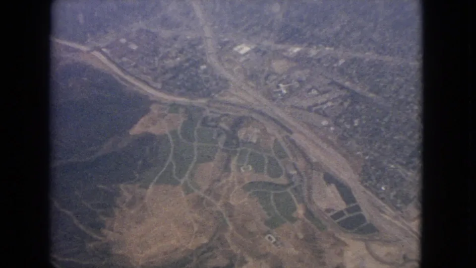 1963 aerial frame over the Barrington, Illinois area with a water edge, broad roadway, fields, and scattered development.