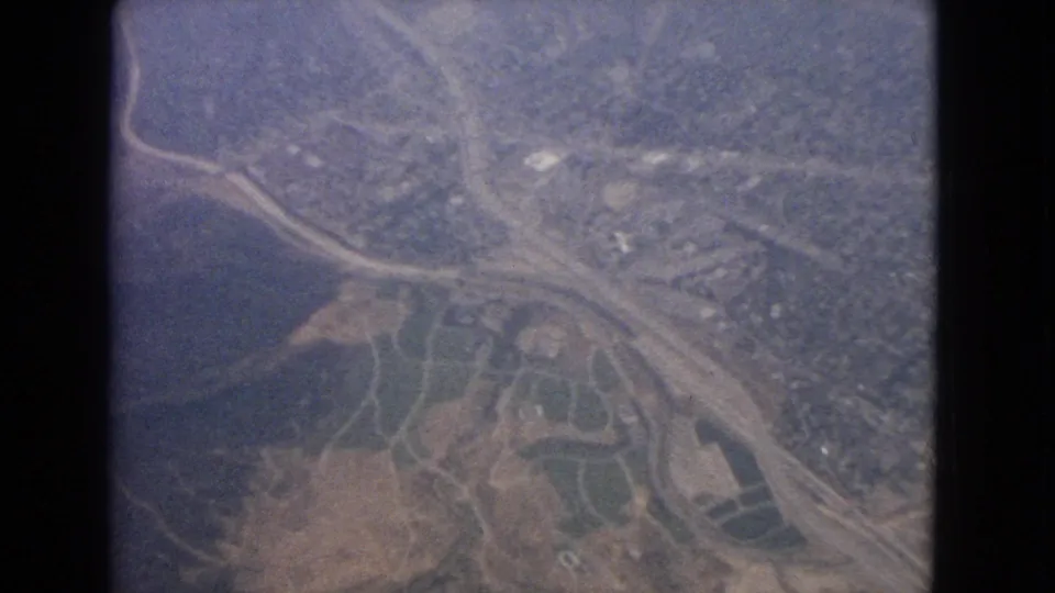 Aerial 8mm view near Barrington, Illinois, with water, intersecting roads, fields, and scattered suburban structures visible below.