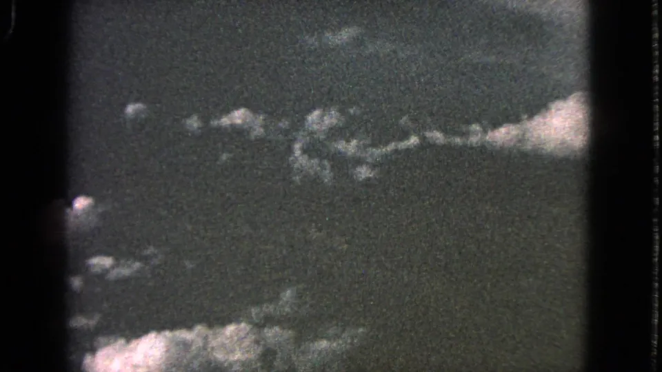 1963 Barrington 8mm frame showing scattered white clouds against a dark, grainy sky with visible film borders.