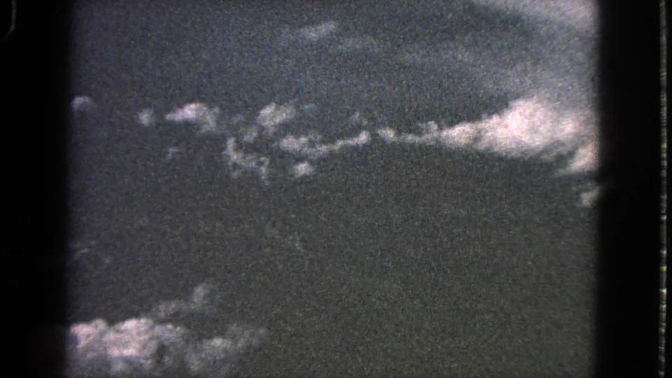 1963 Barrington 8mm frame showing pale cloud shapes across a dark sky, with flicker-like exposure and black film edges.