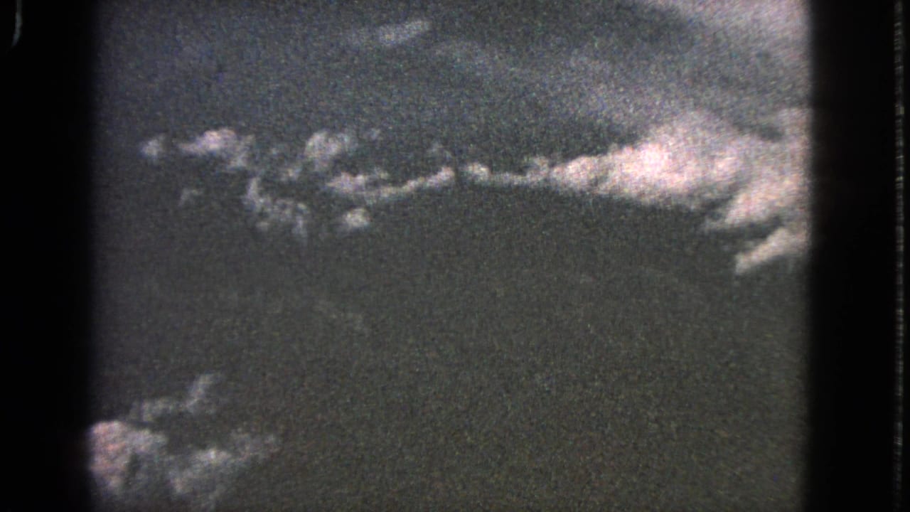 Cloud line and dark surrounding sky framed by black film borders.