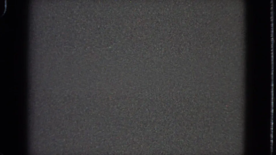 End frame of a short 1963 8mm airplane-window view, showing distant colored lights in a dark, soft-focus scene.