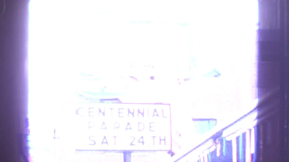 Overexposed Barrington frame where Centennial Parade lettering is faintly visible beside a vertical edge and railing.