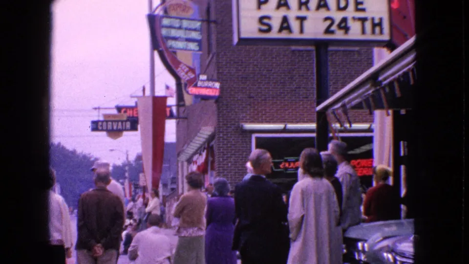 1963 Barrington, Illinois sidewalk scene with adults waiting near the Schaubie Buick marquee and visible street signs.