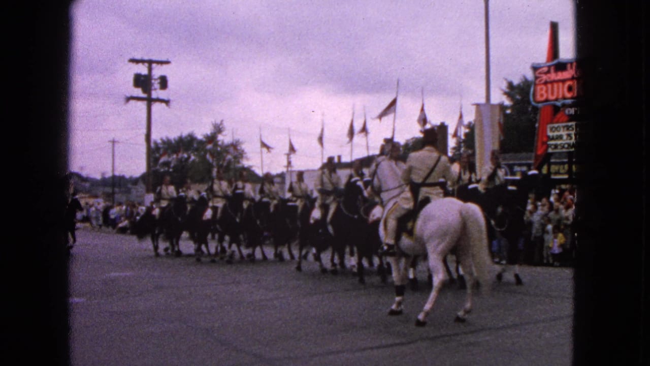 In Barrington, Illinois in 1963, uniformed riders on black and white horses pass spectators near a Schwab's Buick sign.