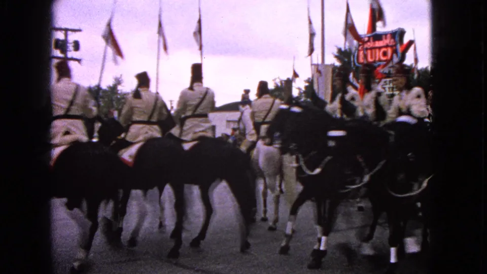 Uniformed horseback riders continue down the Barrington parade route with flags and a Schwab's Buick sign in the background.