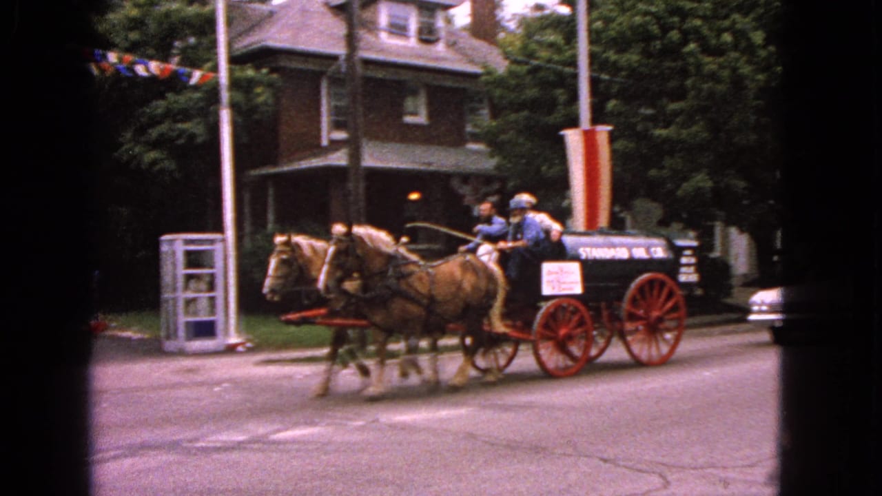 In Barrington, Illinois in 1963, two horses pull a Standard Oil Co. tanker wagon past houses and parade bunting.