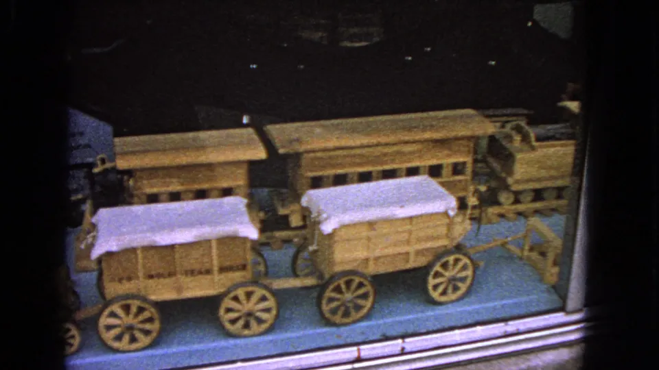 A 1963 home-movie view in Barrington shows covered wooden wagons and part of a toy locomotive behind glass.
