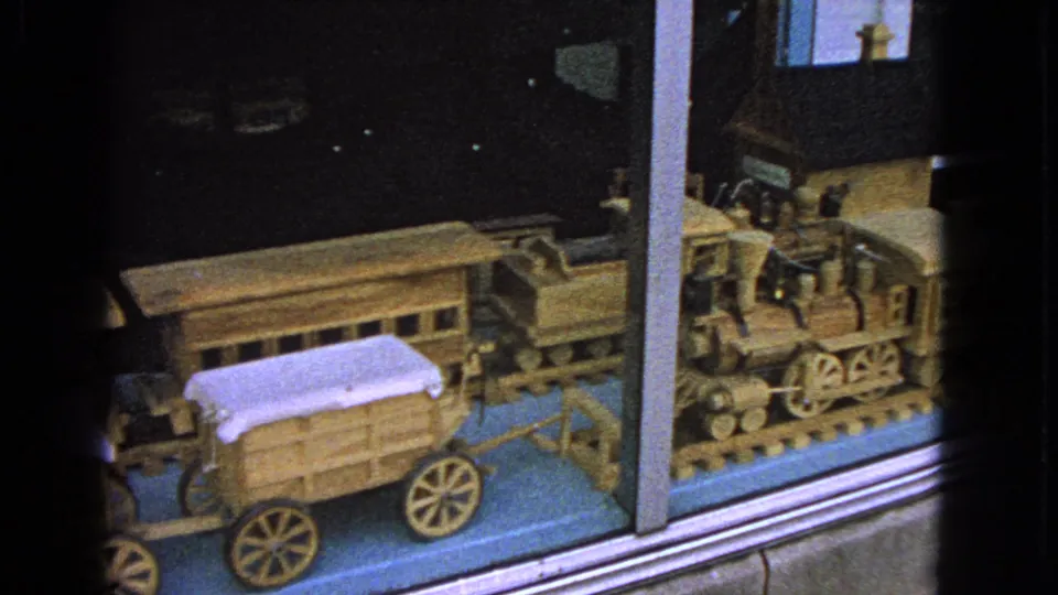The final 1963 Barrington frame shows the end of the glass-case display with a wooden locomotive, wagon, and track base.