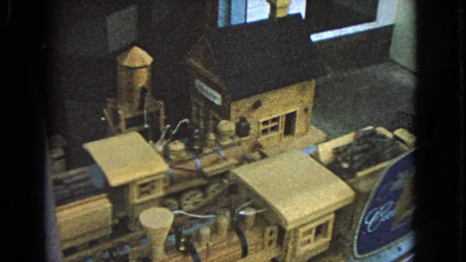 1963 Barrington, Illinois frame with a wooden model train, water tower, small station, and glass reflections.