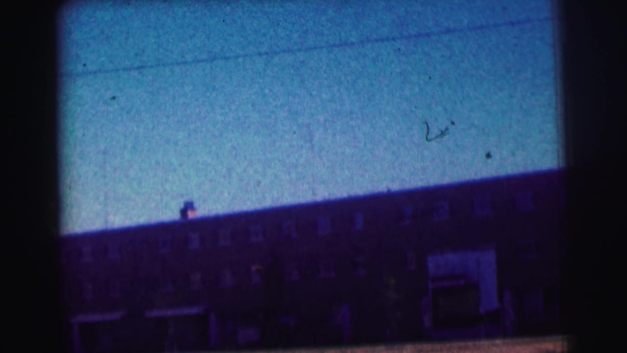 1963 8mm view of a Bowling Green University building facade, heavily blue-tinted with dark film edges.