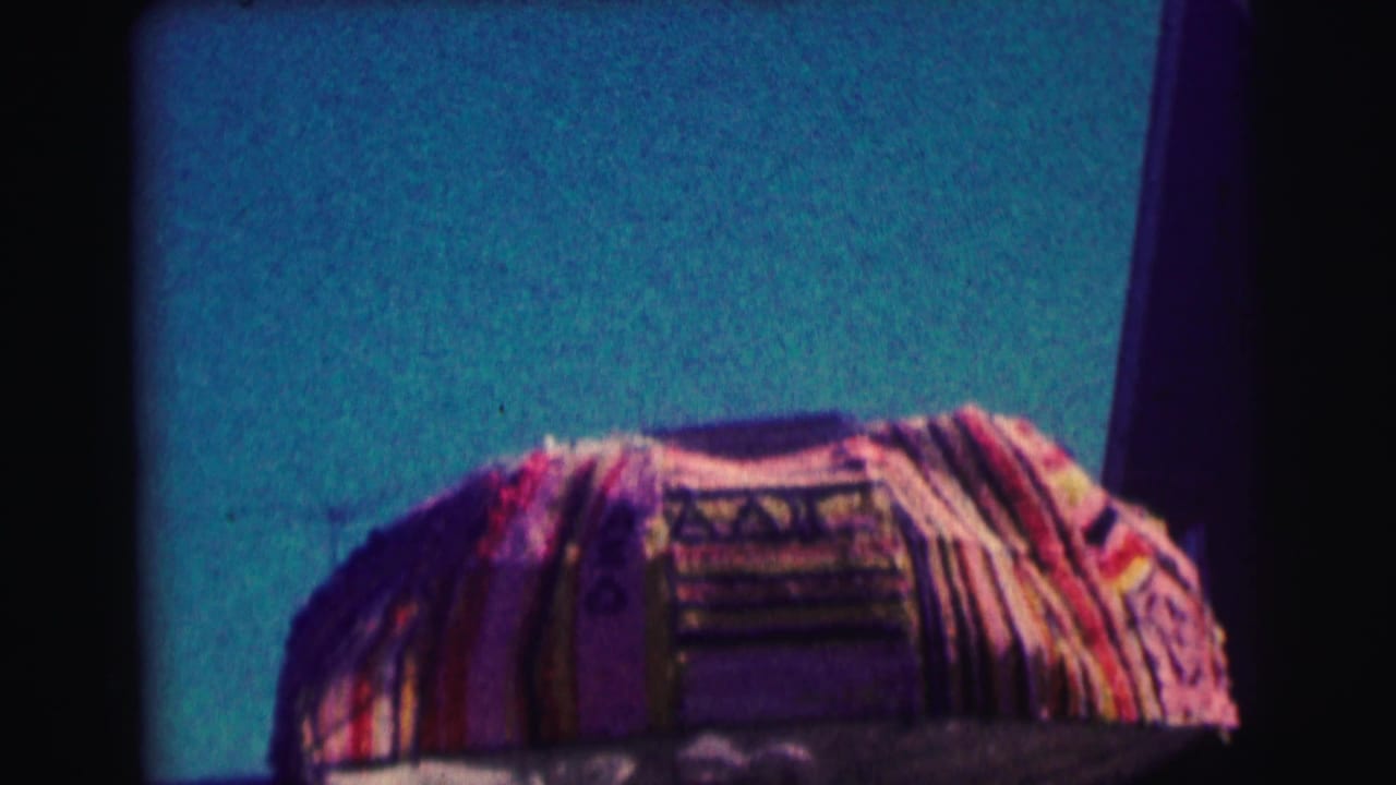 Patterned canopy edge against a teal wall or facade in dark 8mm footage.