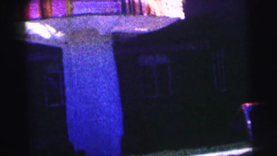 1963 Bowling Green University frame showing the canopy support column, dark windows, and lawn edge at night.