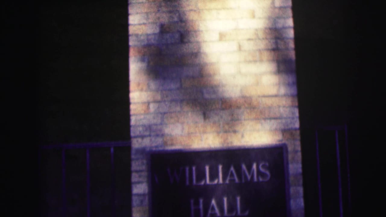 8mm frame from Bowling Green State University showing a brick entry pillar and dark Williams Hall plaque in uneven light.