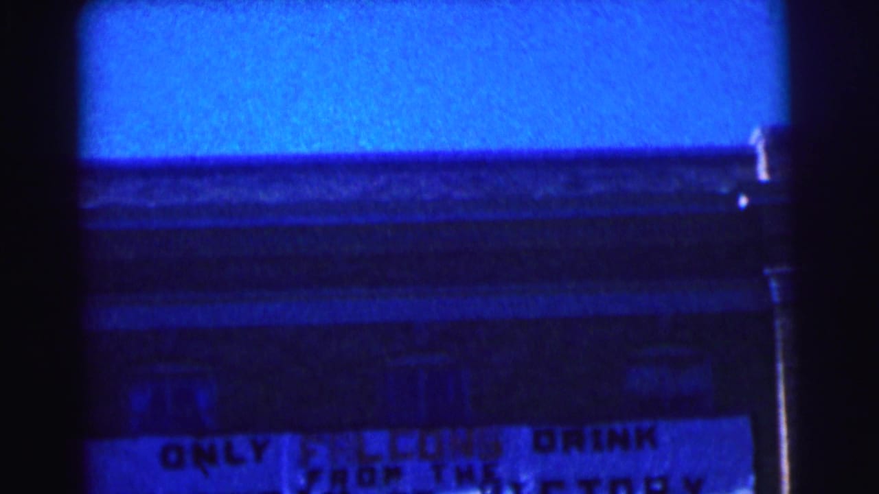 Blue-cast 8mm frame of a Bowling Green University exterior with part of the Falcons sign visible.