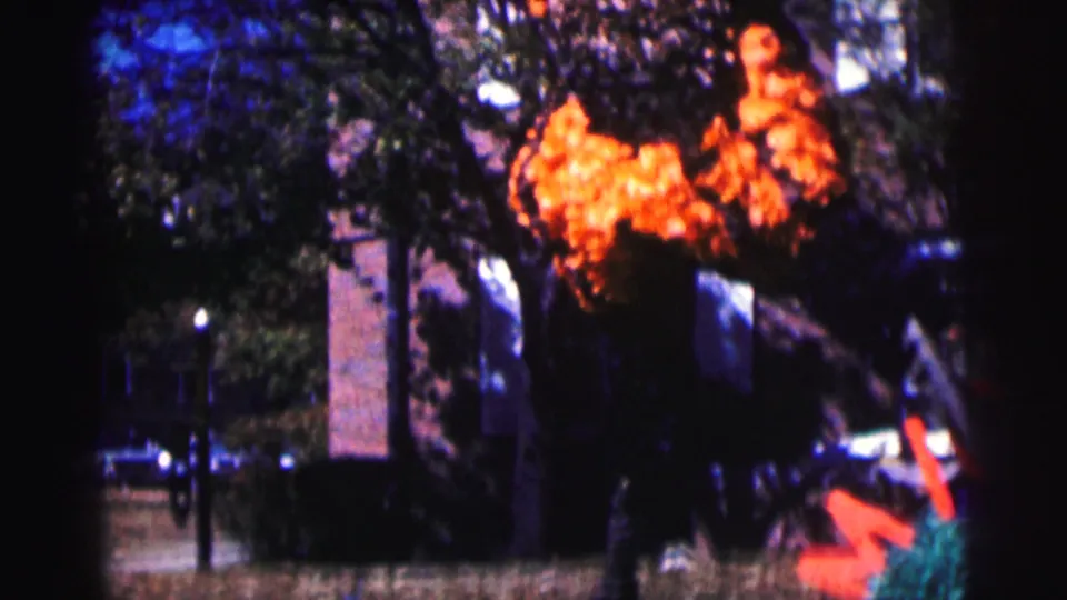 1963 Bowling Green University frame with the large colorful mascot or float seen wider near trees, a building, and parked cars.